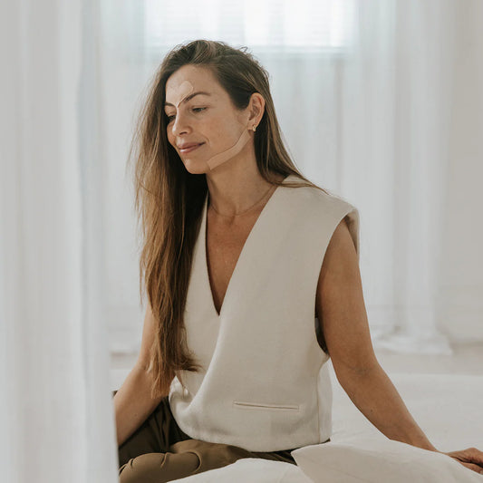 Deze oude techniek, met gezichtsvriendelijke tape, helpt de gezichtsspieren op hun plek te houden en lift de huid subtiel.