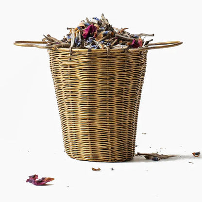 Gros plan de la passoire à thé Anima Mundi Woven Brass avec ses anses pour la poser sur une tasse ou un mug