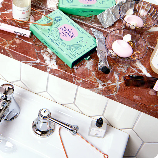 Cosmic Dealer copper tongue scraper in a stylish bathroom setting for fresh breath and mindful oral care