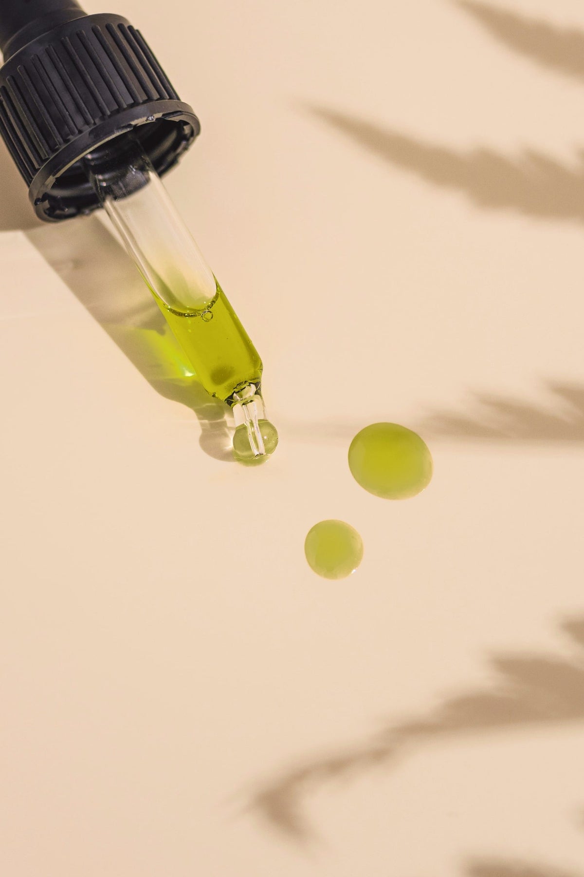 Textuur van een groen-gouden gezichtsolie met pipet