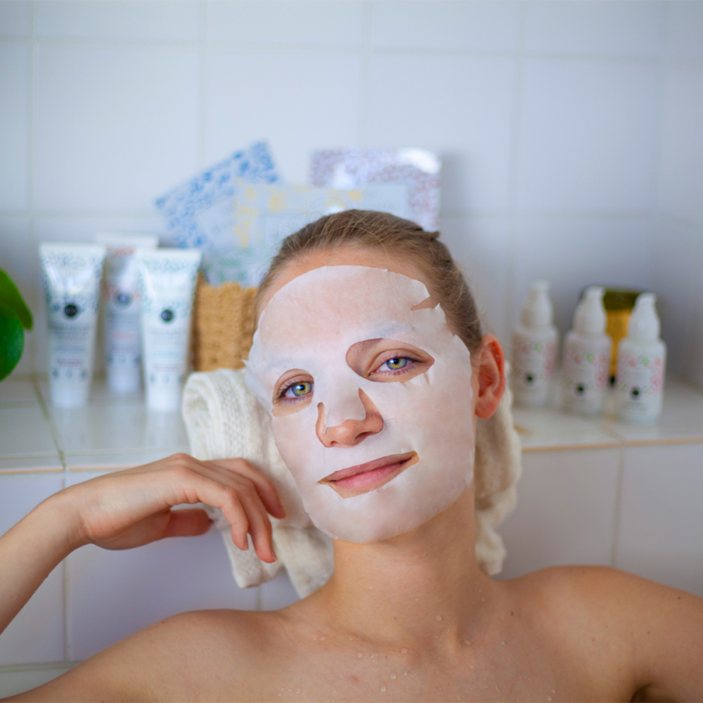 Vrouw gebruikt Les Poulettes anti-age sheetmasker voor huidverzorging