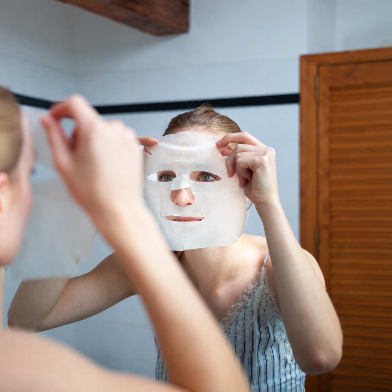 Vrouw brengt Les Poulettes Radiant Glow sheetmasker aan